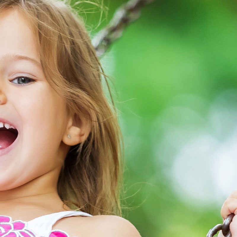 A little girl playing on a swing