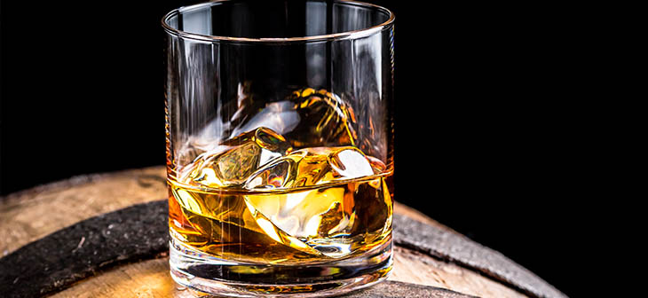 Glass of whisky on a barrel