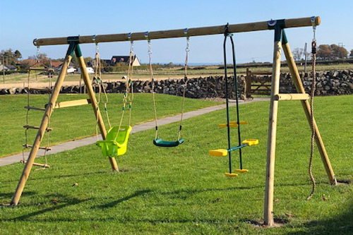 Swing set with three swings on the grass