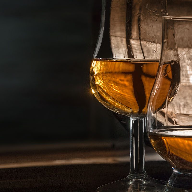 Two glasses of whisky and a whisky barrel