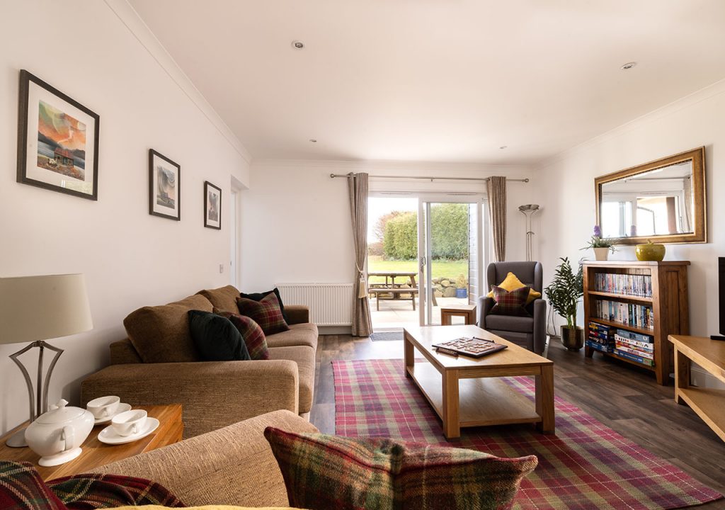 The living room and patio doors in the accessible Lodge 6 at Elderburn Luxury Lodges