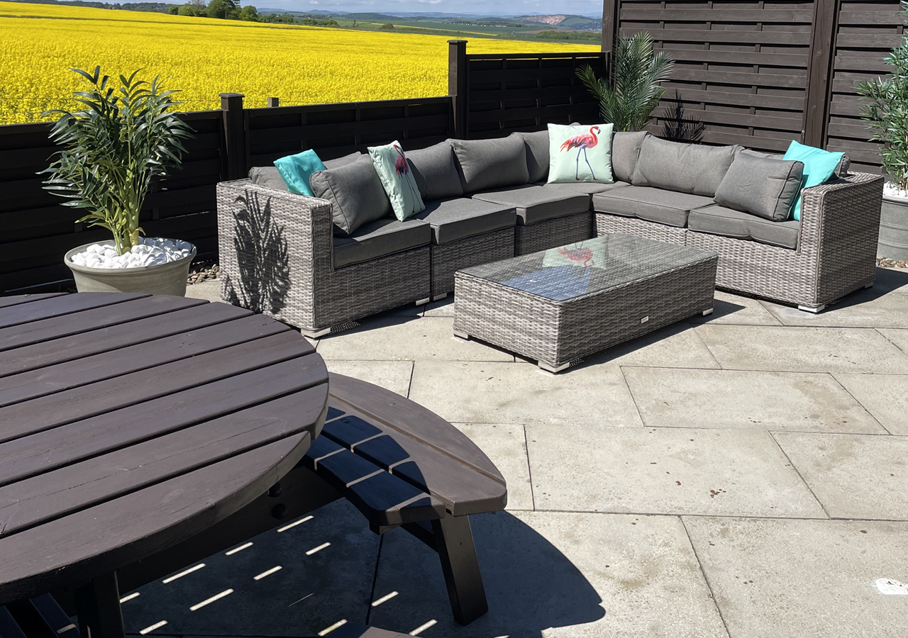 Lodge 4 patio with outdoor seating and yellow fields in our Self-catering in Fife lodges